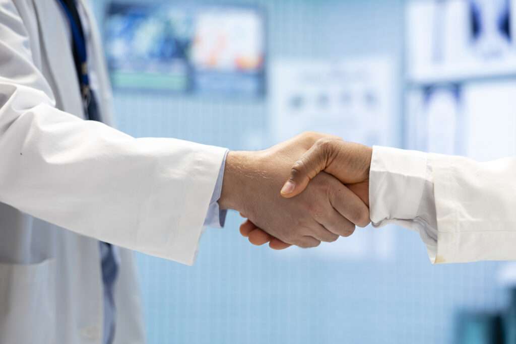 Surgeon and patient shaking hands at the end of a hand and wrist consultation
